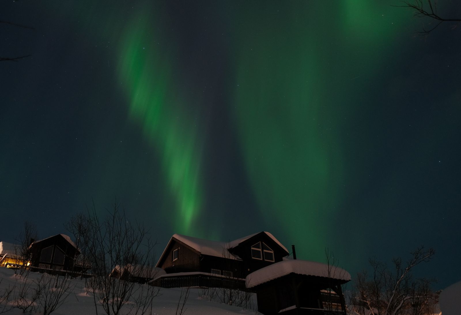 The northern lights over snowy cabins