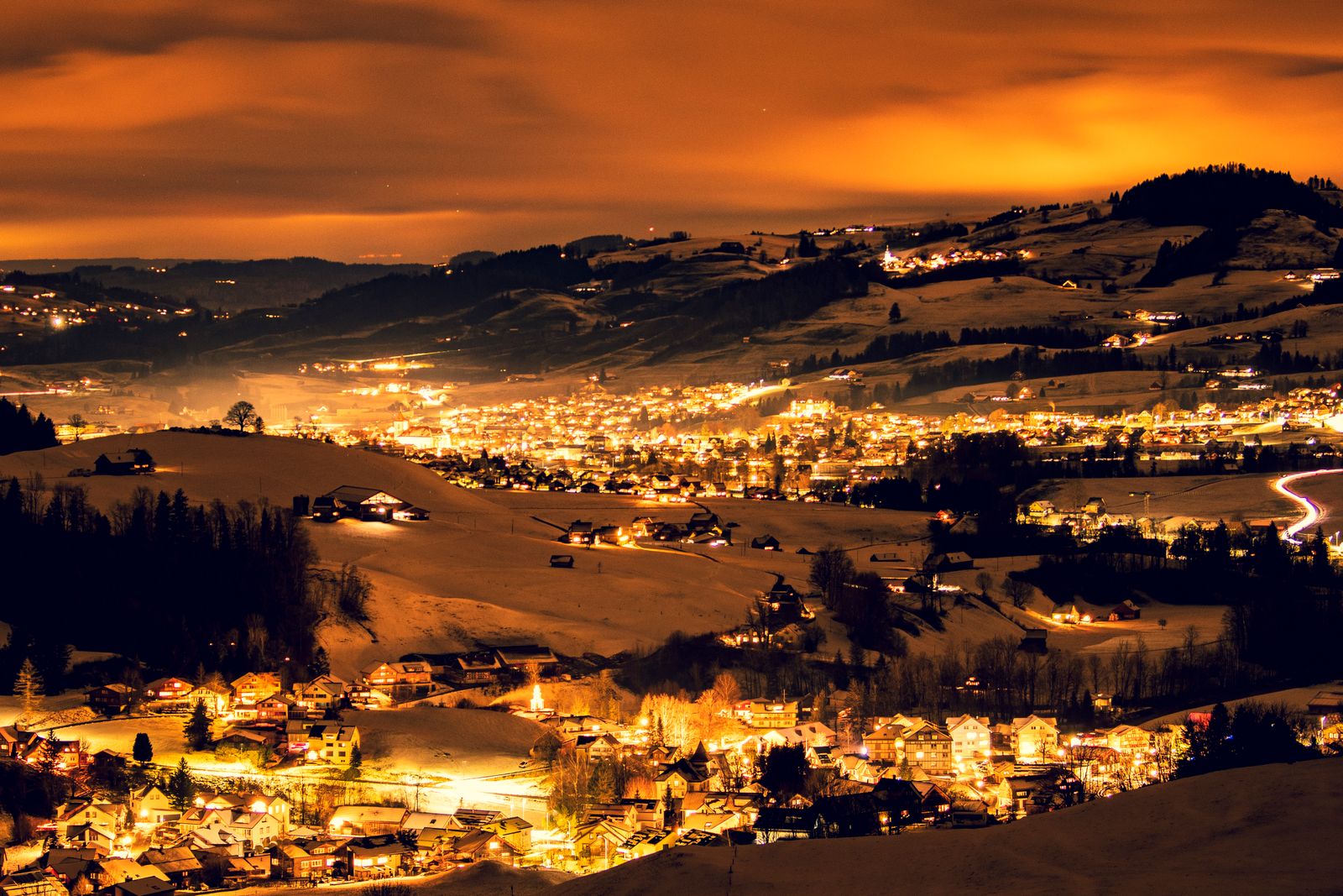 Village lights scattered across the Appenzell hills on a winter night