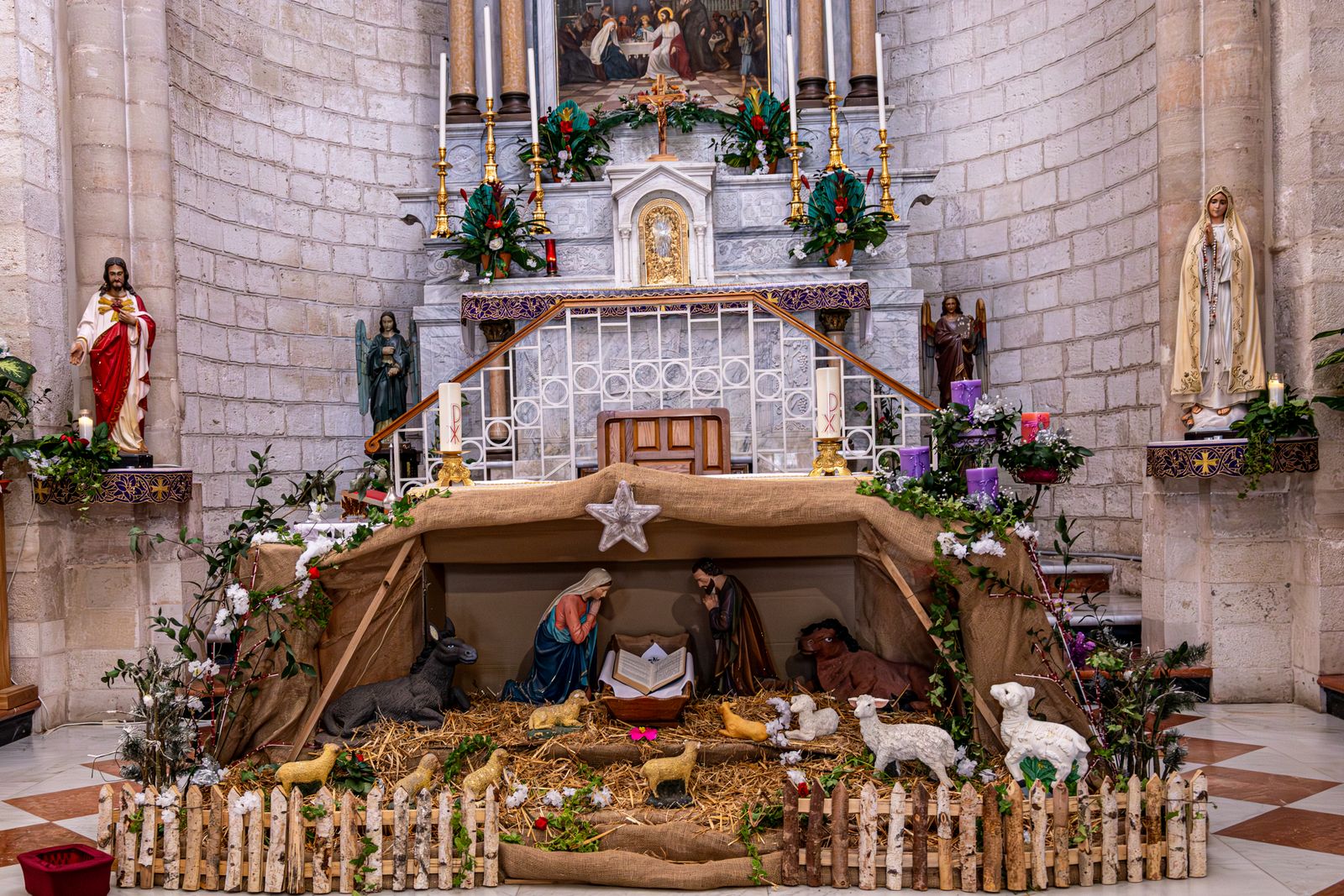 A Christmas crib with figures and straw in a church