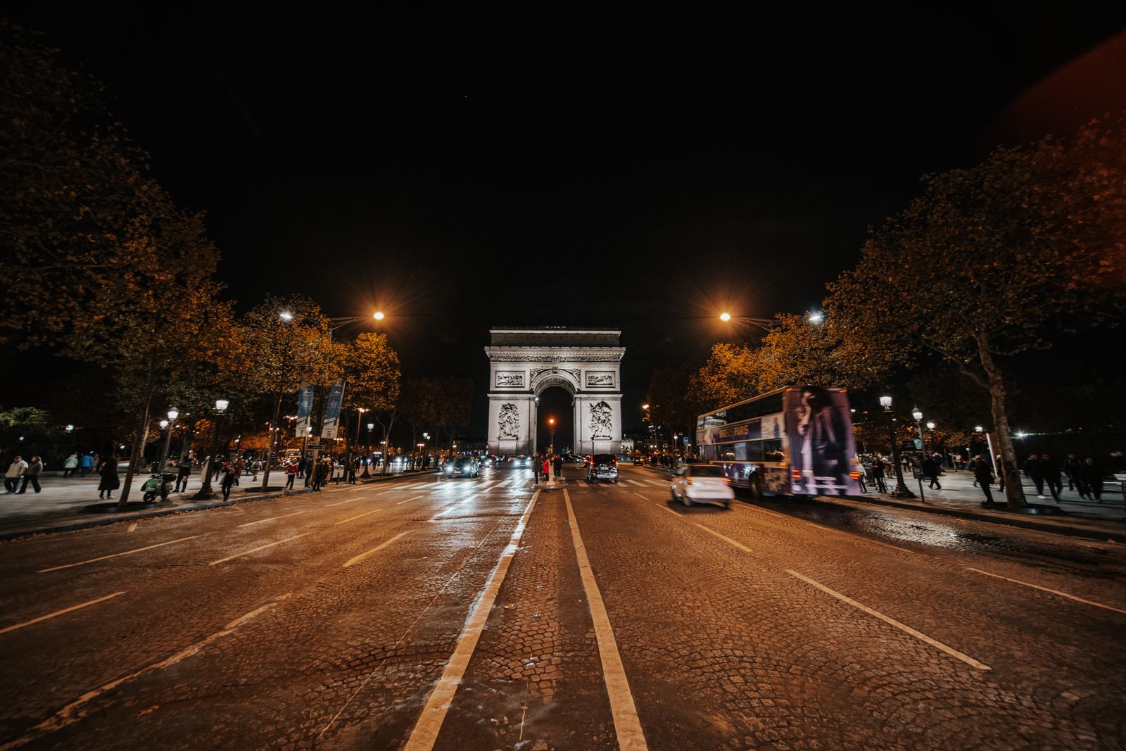 The Arc de Triomphe at the end of a lit avenue at night