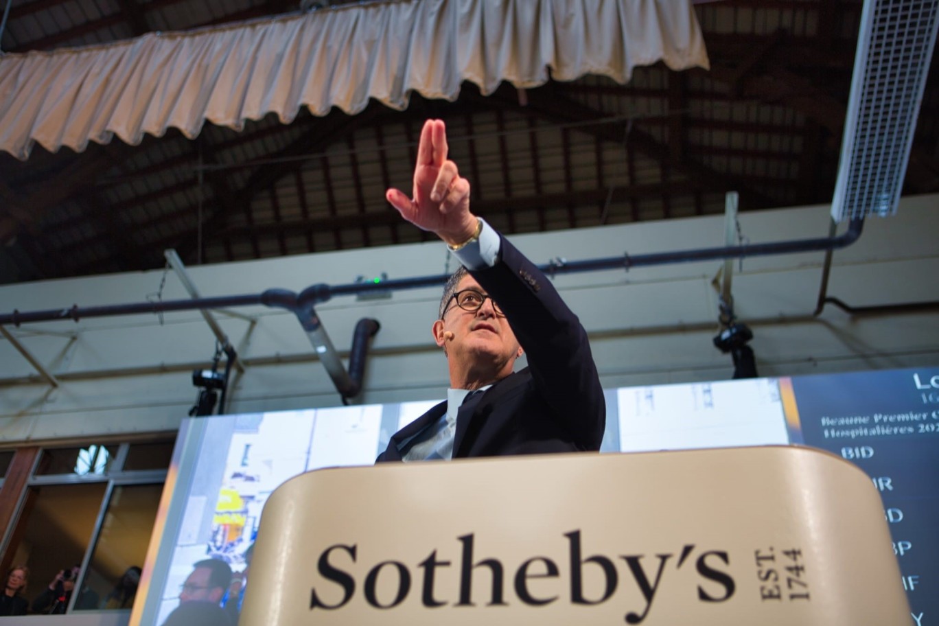 The auctioneer takes a bid from the Sotheby's rostrum under the covered market at Beaune