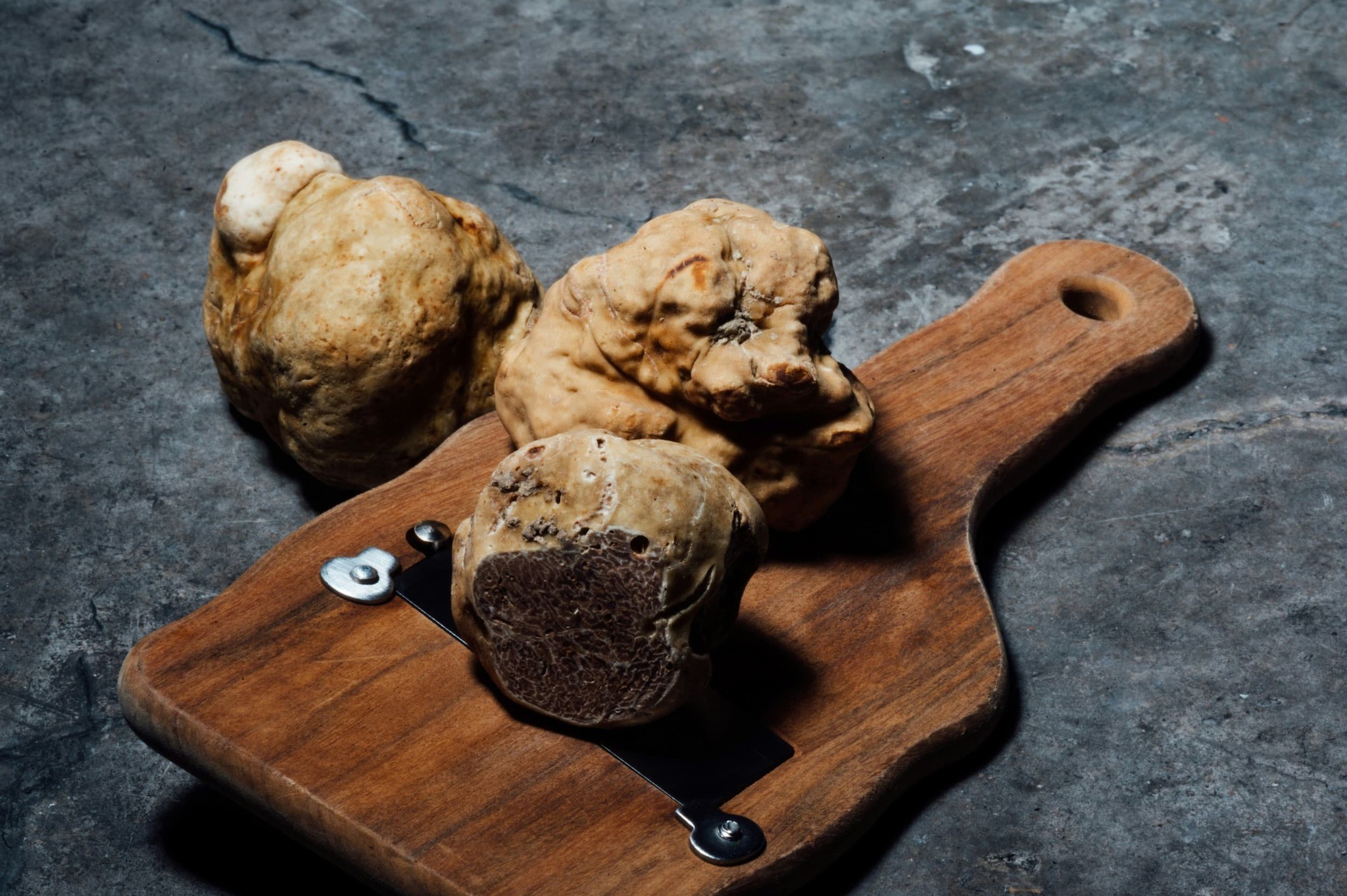Truffles on a board, one cut open to show the marbled flesh