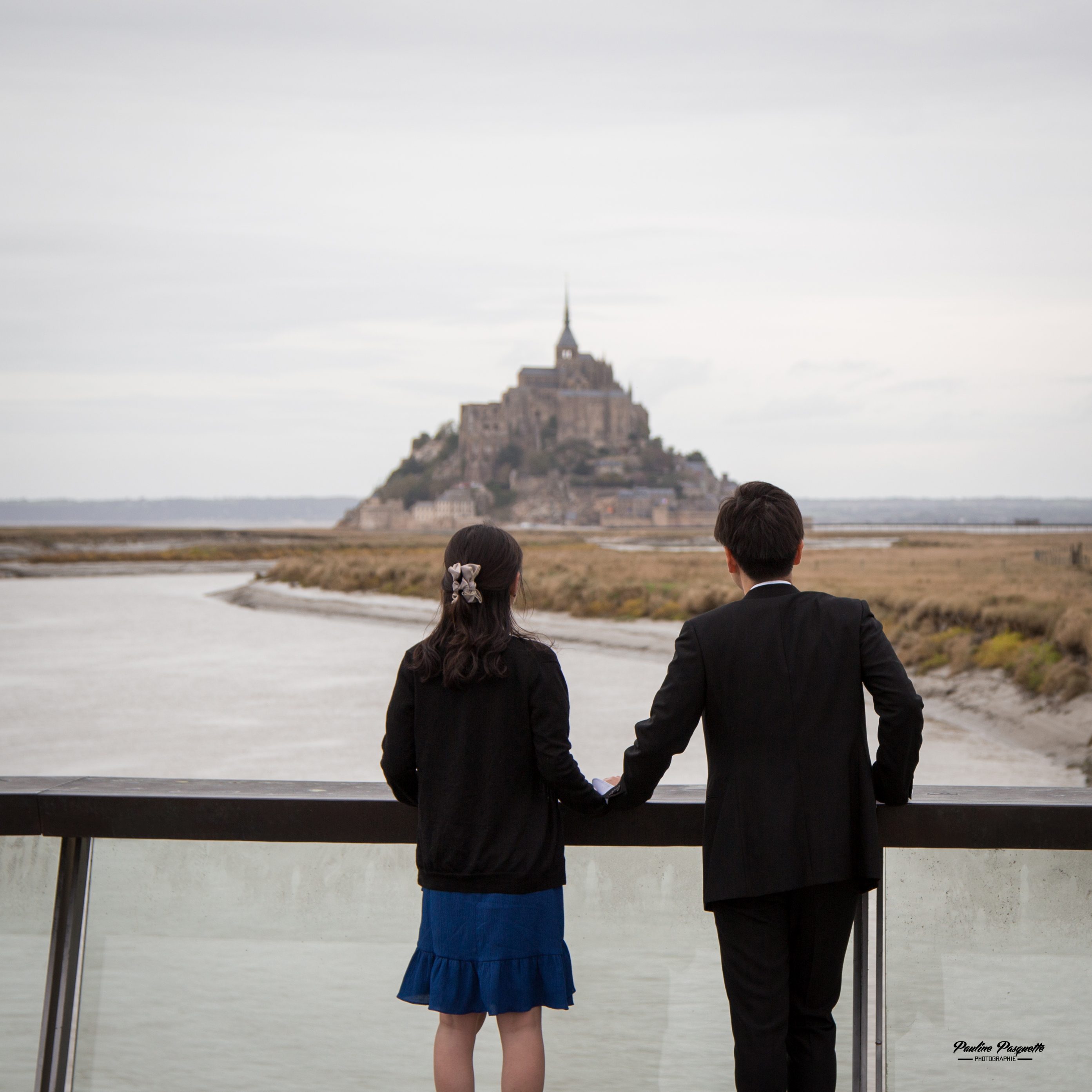 The couple before the abbey of Mont-Saint-Michel across the bay