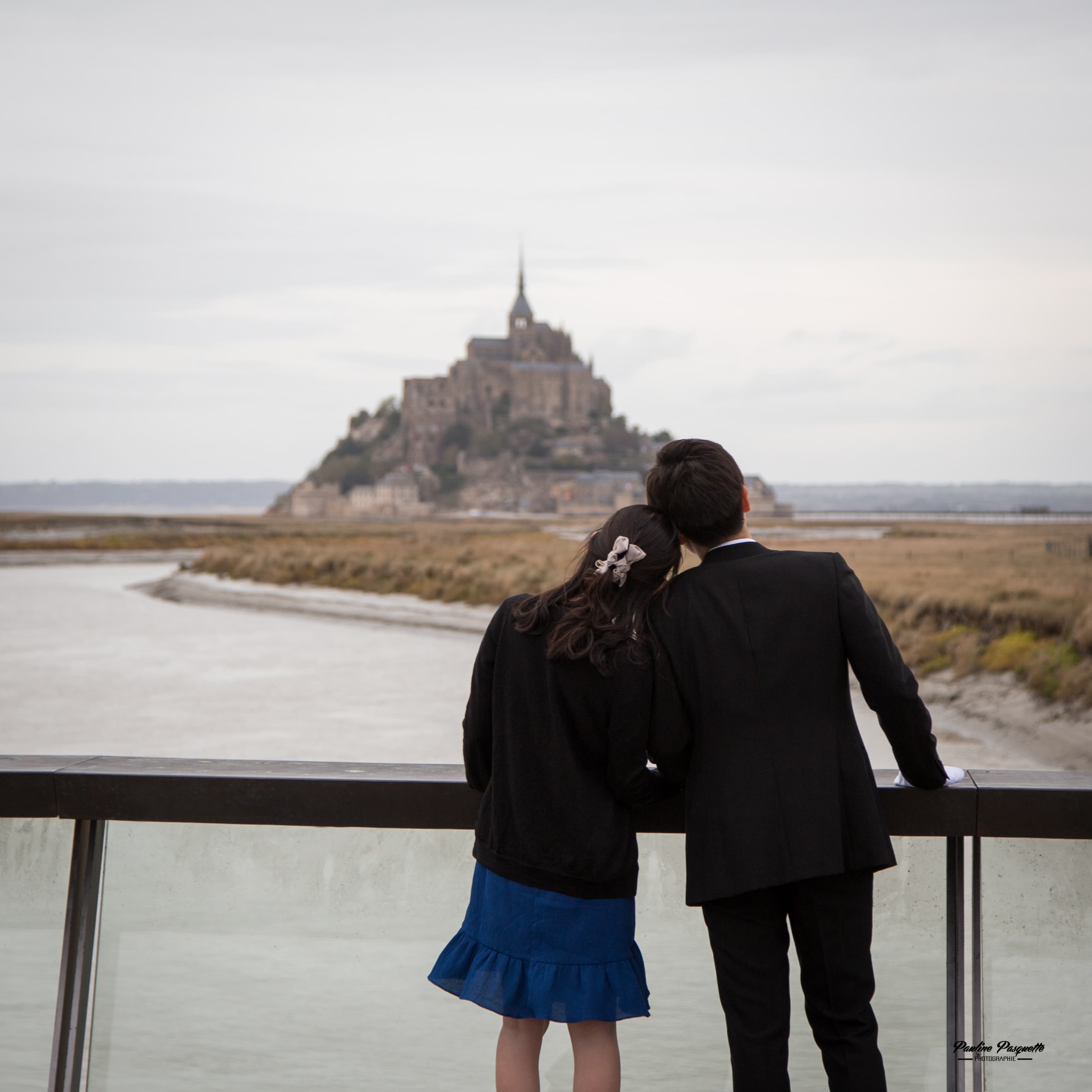 The couple facing the abbey of Mont-Saint-Michel at dusk